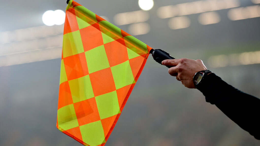 Billede af linjedommer der løfter flaget for off-side